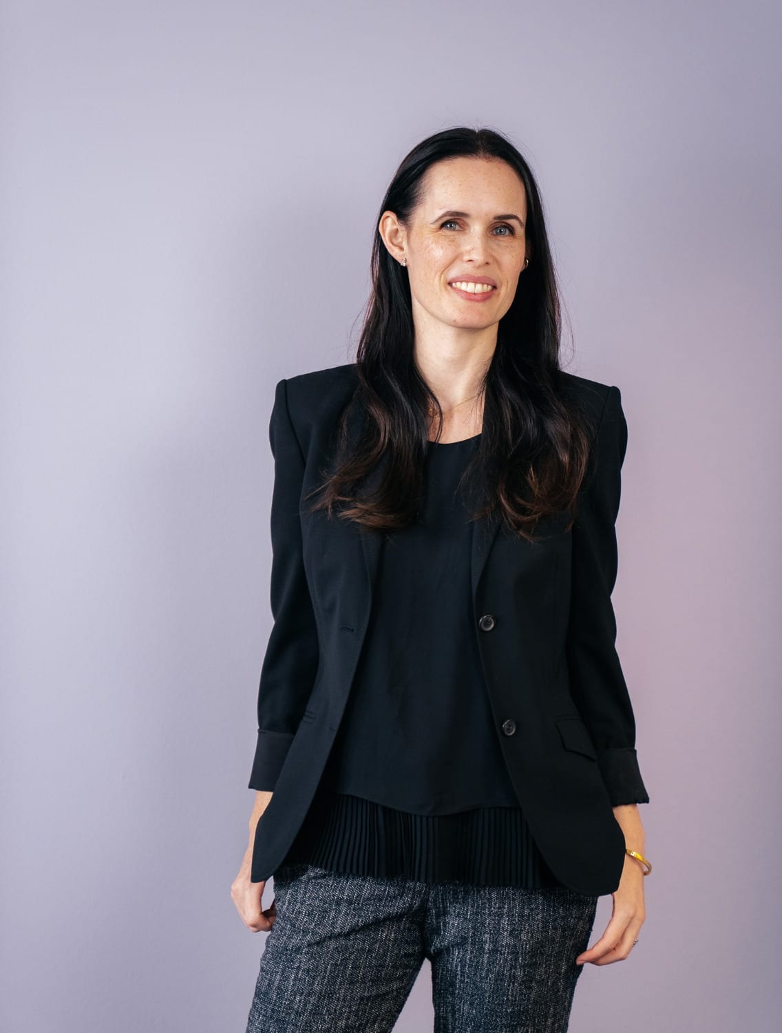 Porträt von Jessica Ryan-Tietz im dunklen Blazer vor hellem Hintergrund