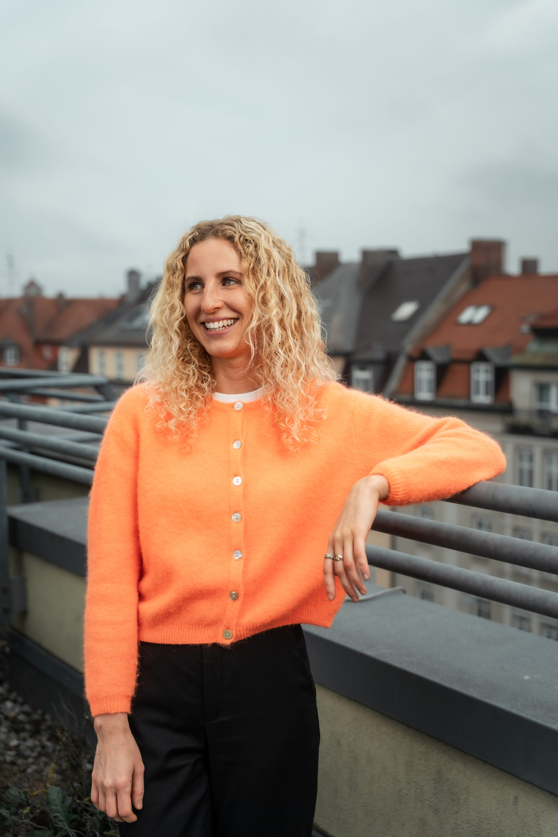 Anthea Wagner steht am Geländer auf einer Dachterrasse